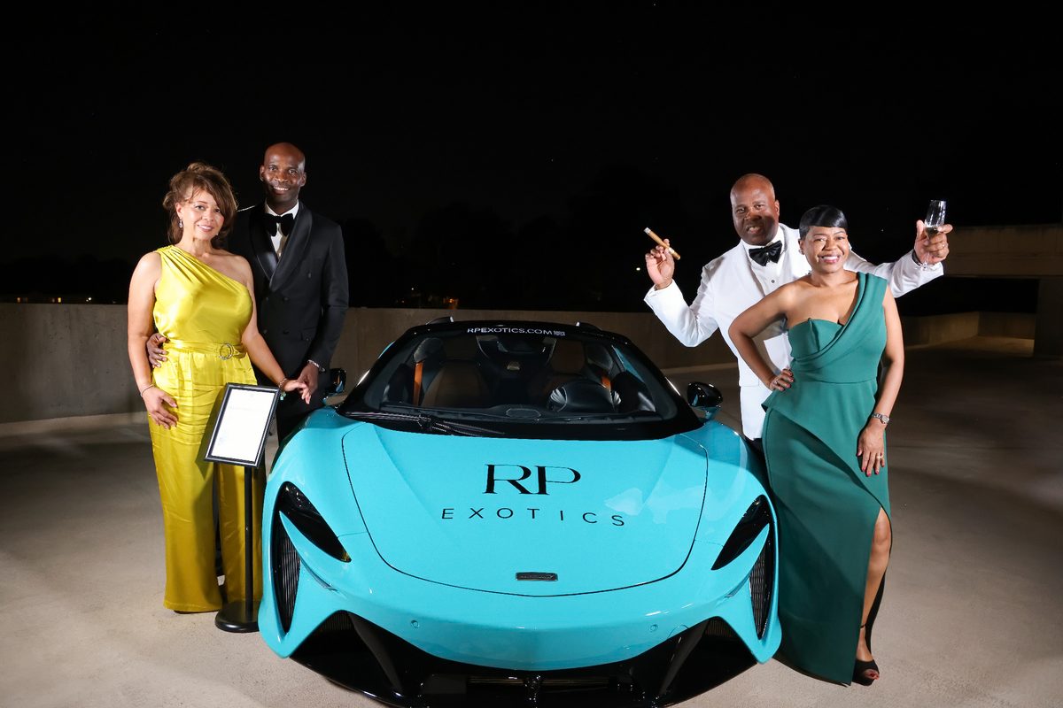 Guests raising a toast beside a teal RP Exotics supercar