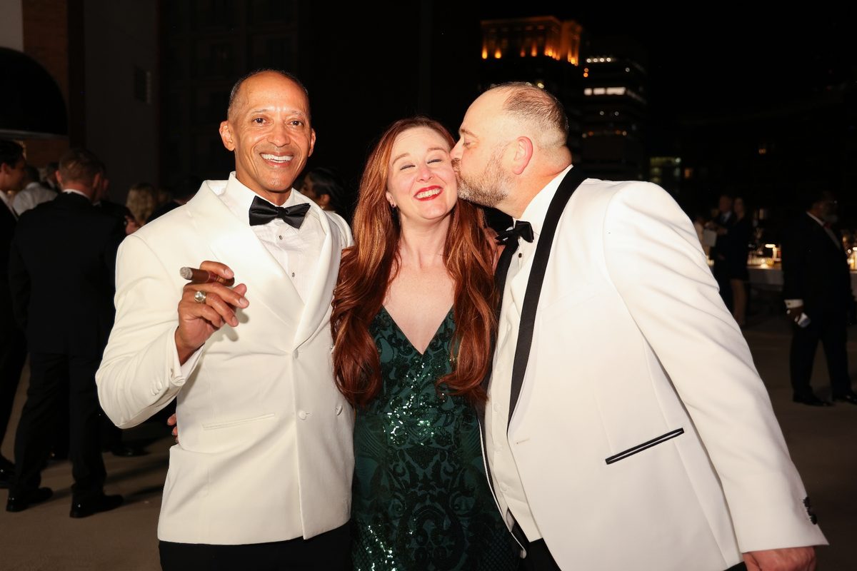 Three guests laughing together during the celebration