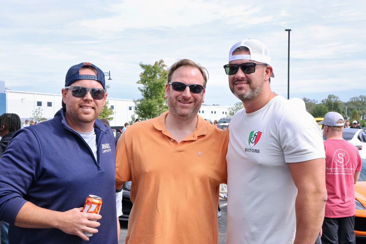 Three guests catching up at the car show