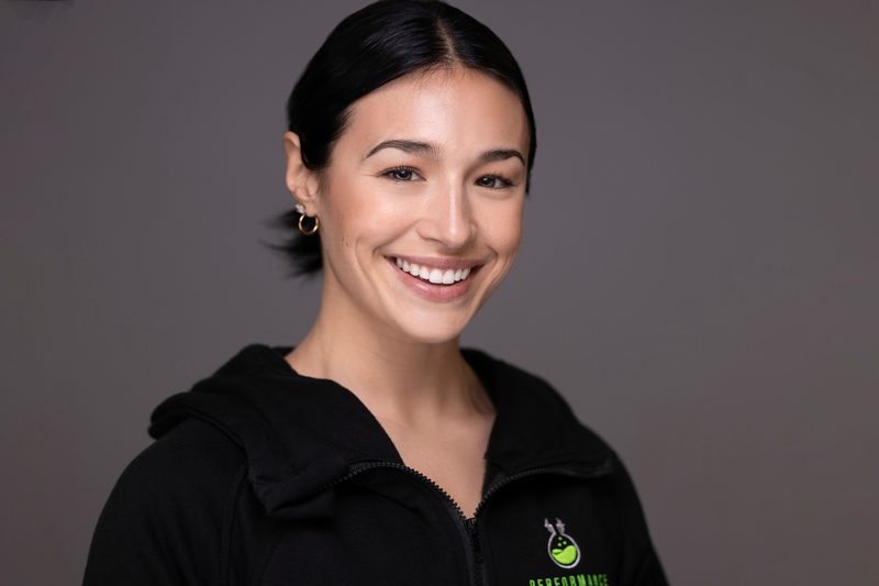 Studio portrait of a woman in a black athletic top on a dark background