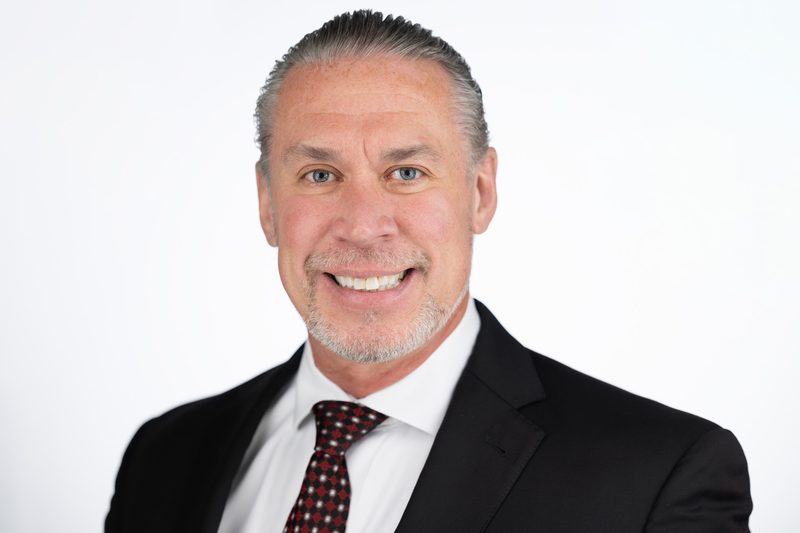 Corporate headshot of a smiling businessman in a suit