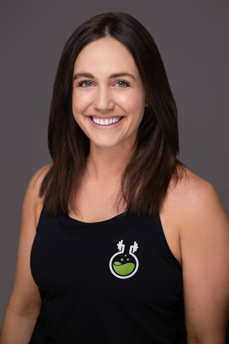 Studio headshot of a woman in a branded polo on a dark background