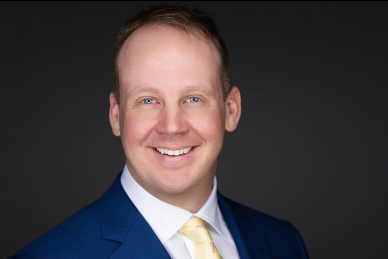 Professional headshot on dark background