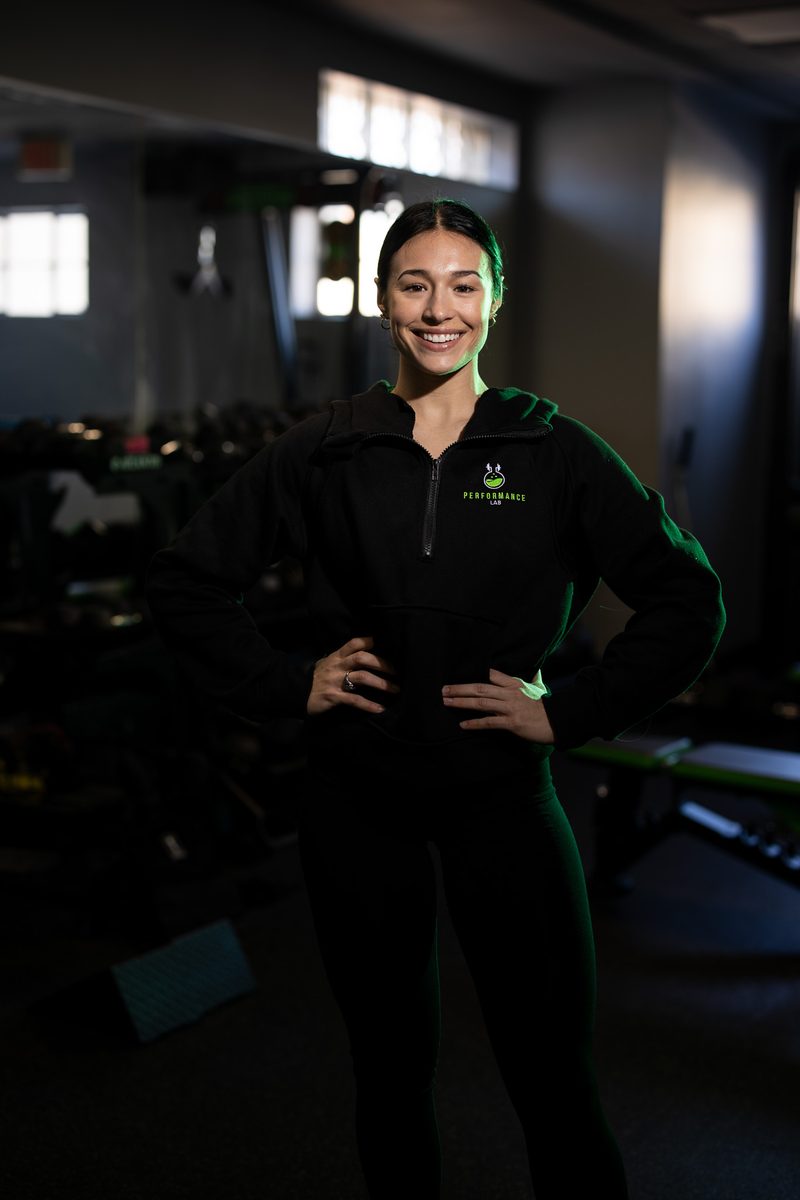 Environmental team portrait of a woman in a branded polo at a fitness gym